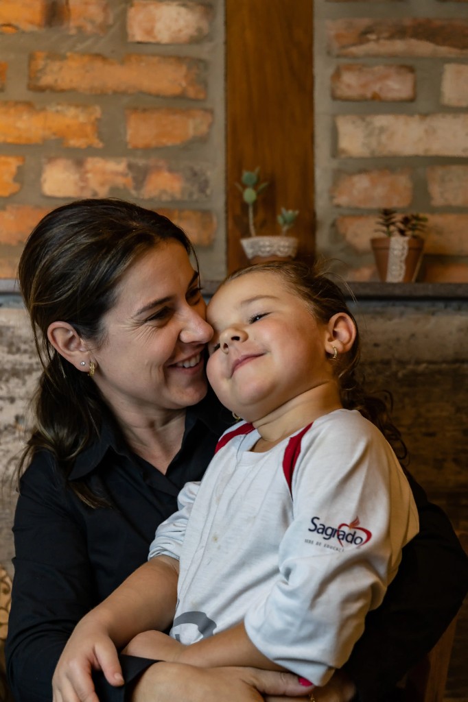 Mãe e filha em momento de carinho durante celebração familiar na Trattoria Primo Camilo