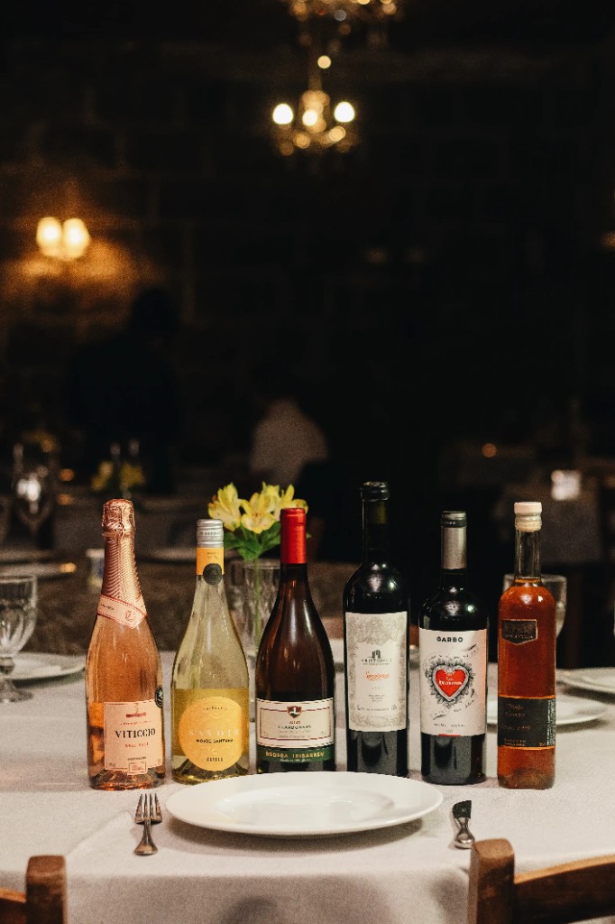 Garrafa de vinhos e mesa posta para data especial na Trattoria Primo Camilo