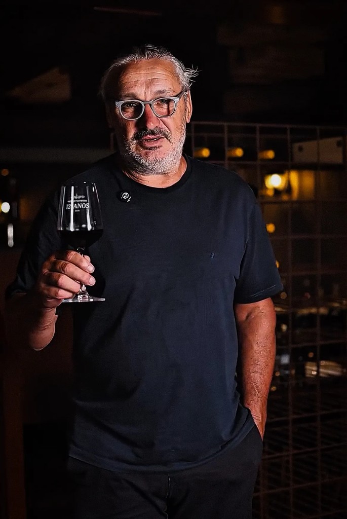 Altemir Pessali na adega da Trattoria Primo Camilo, com taça de vinho